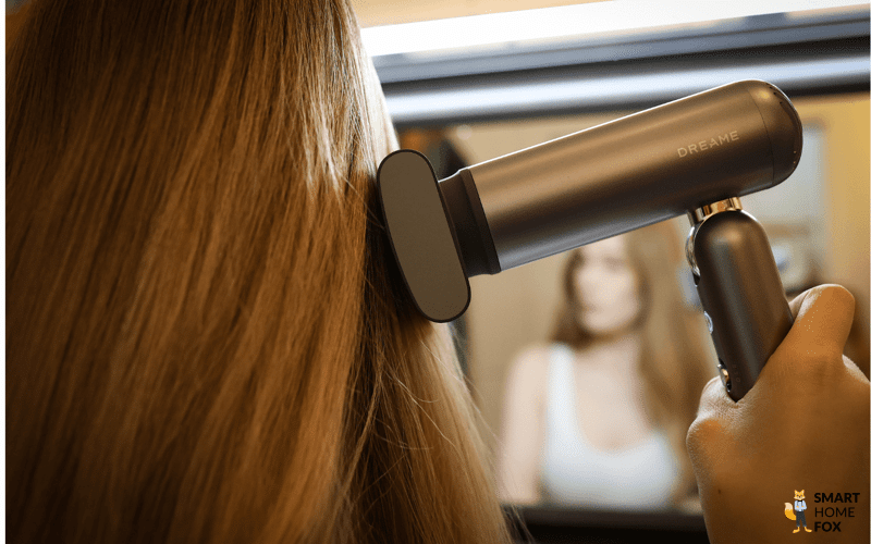 mit dem Anti Frizz Aufsatz des Dreame Pocket werden lange blonde Haare bearbeitet.